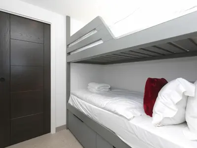a bedroom with a bunk bed with white sheets at Louies Loft in St Ives