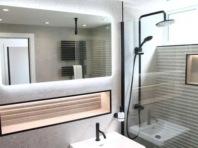 a bathroom with a shower and a sink and a mirror at Louies Loft in St Ives