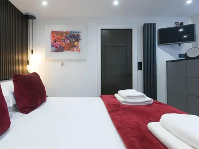 a bedroom with a white bed with a red blanket at Louies Loft in St Ives