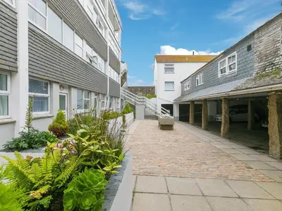 a brick walkway between two buildings with plants at Louies Loft in St Ives