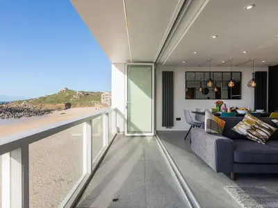 a living room with a view of the beach at Louies Loft in St Ives