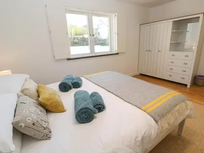 a bedroom with a bed with blue towels on it at Chilowan in Tintagel