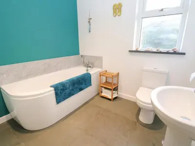 a bathroom with a tub and a sink and a toilet at Chilowan in Tintagel