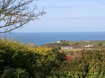 a house on top of a hill next to the ocean at Chilowan in Tintagel