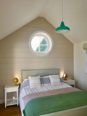 a bedroom with a large bed with a window at The little post house. A perfect village retreat, with stunning views. in Boscastle