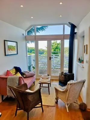 a living room with a couch and chairs and a fireplace at The little post house. A perfect village retreat, with stunning views. in Boscastle