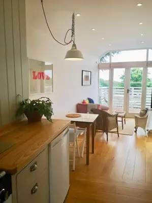 a kitchen and living room with a table and a dining room at The little post house. A perfect village retreat, with stunning views. in Boscastle