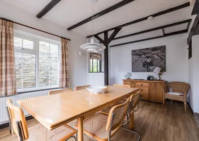 a dining room with a wooden table and chairs at Little Pityme in Wadebridge