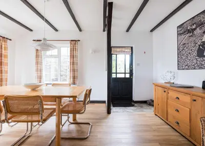 a dining room with a wooden table and chairs at Little Pityme in Wadebridge