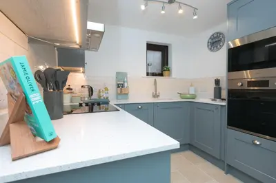 a kitchen with blue cabinets and a counter top at Dream Achieved in St Ives