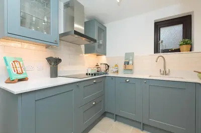 a kitchen with blue cabinets and white counter tops at Dream Achieved in St Ives