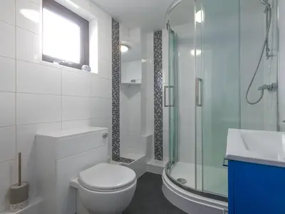 a bathroom with a toilet and a glass shower at Dream Achieved in St Ives