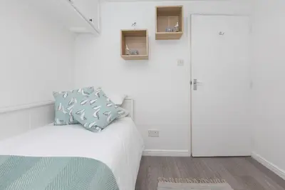 a bedroom with a bed with a blue pillow on it at Dream Achieved in St Ives