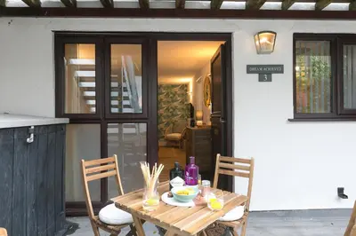 a wooden table and chairs on a patio at Dream Achieved in St Ives