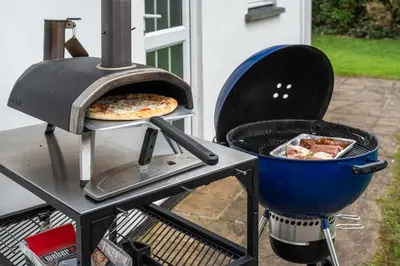 a grill with a pizza and a pan of food at Finest Retreats - Sunny Nook in Padstow