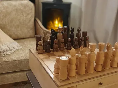 a chess set on a table in a living room with a fireplace at Oakenhurst in Fowey