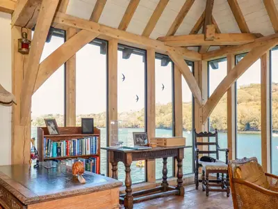 a room with a table and chairs and windows at Oakenhurst in Fowey