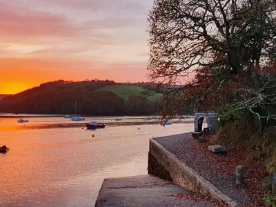 a sunset over a body of water with boats at Oakenhurst in Fowey