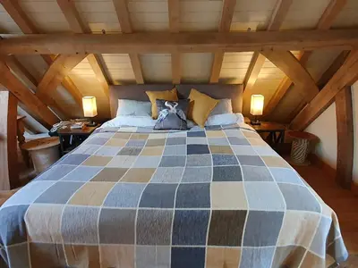 a bedroom with a large bed in an attic at Oakenhurst in Fowey