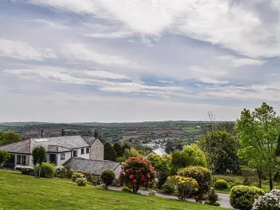 a house on a hill with a green yard at Bolivar Barn in Gwennap