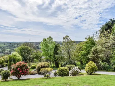 a garden with bushes and flowers on a lawn at Bolivar Barn in Gwennap
