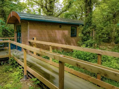 a cabin in the woods with a wooden fence at Woodpecker - Uk43451 in Hayle