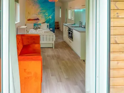 a kitchen with an orange couch in a room at Woodpecker - Uk43451 in Hayle