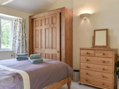 a bedroom with a bed and a dresser and a mirror at Moorside - Uk43497 in Lostwithiel