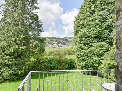 a fence in the middle of a field between two trees at Moorside - Uk43497 in Lostwithiel