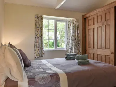 a bedroom with a large bed with a window at Moorside - Uk43497 in Lostwithiel