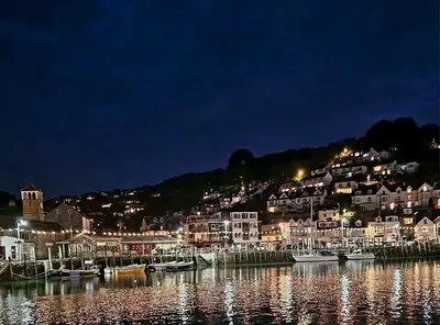 a group of boats docked in a harbor at night at 4 Quay View, Looe in Looe