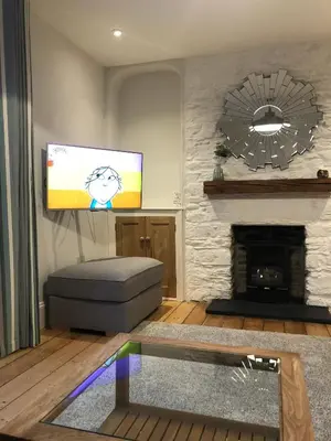 a living room with a tv and a fireplace at 4 Quay View, Looe in Looe