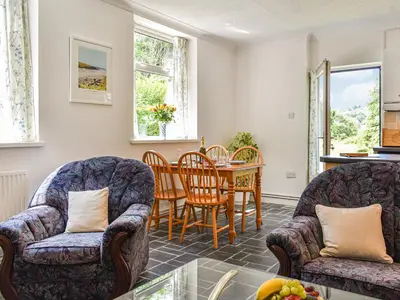 a living room with two chairs and a table at Poundhouse - Uk43496 in Lostwithiel