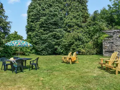 a table and chairs and an umbrella in the grass at Poundhouse - Uk43496 in Lostwithiel