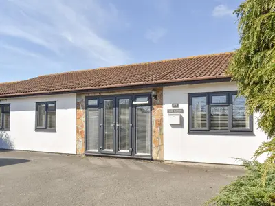 a white house with black windows and a driveway at The Batch in St Merryn