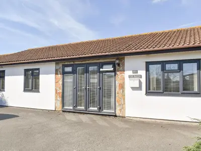 a white house with black windows and a driveway at The Batch in St Merryn