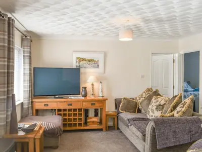 a living room with a couch and a flat screen tv at The Batch in St Merryn