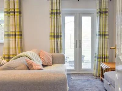 a living room with a couch and a window at The Batch in St Merryn