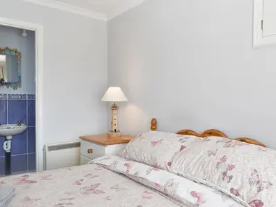 a white bedroom with a bed and a sink at The Batch in St Merryn