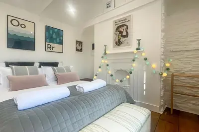 a bedroom with two beds and a christmas tree at Luxury holiday cottage by the harbour in St Mawes in Saint Mawes