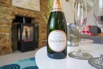 a bottle of wine sitting on a table with glasses at Luxury holiday cottage by the harbour in St Mawes in Saint Mawes