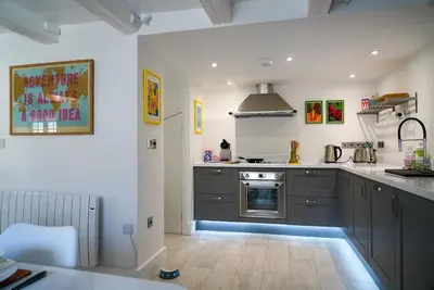 a kitchen with gray cabinets and a stove at Luxury holiday cottage by the harbour in St Mawes in Saint Mawes