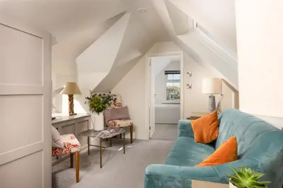 a living room with a blue couch and chairs at Beach Vista, harbourside in St Ives in St Ives