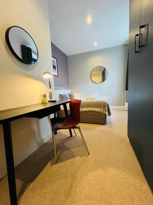 a room with a desk with a bed and a mirror at 8, St Marys , Private Double Ensuite Room - Room Only- Truro in Truro