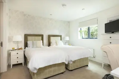 a bedroom with two beds and a flat screen tv at Apartment 3 at Porthminster Mews in St Ives