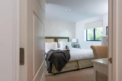 a bedroom with a bed with white sheets and a window at Apartment 3 at Porthminster Mews in St Ives