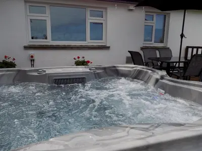 a hot tub with water in it in a backyard at Brookfield in Bude