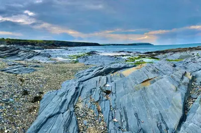 a rocky beach with the ocean in the background at Trevone Bay Seaside Home For 4 - Close To Beach and Padstow in Padstow