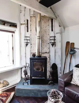 a living room with a fireplace and a couch at The Old Stores, Luxury beach side selfcatered holiday cottage above the beach in Porthleven