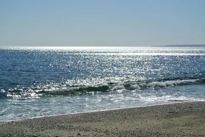 a beach with a small wave in the ocean at The Old Stores, Luxury beach side selfcatered holiday cottage above the beach in Porthleven